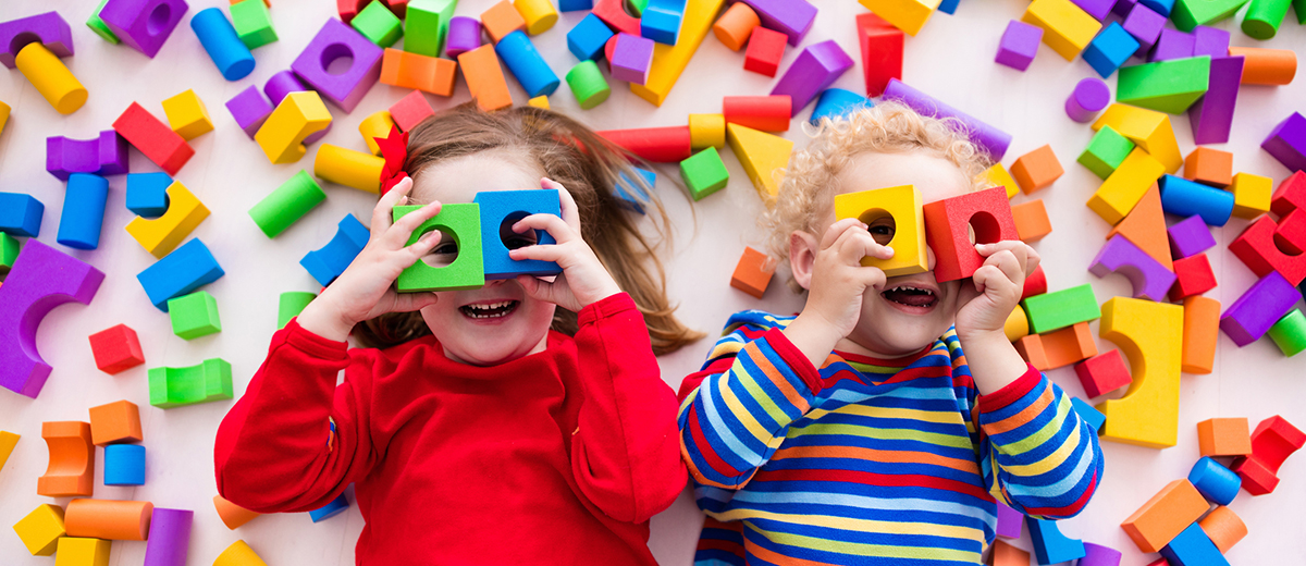 Children playing with colorful blocks building a block tower Educare