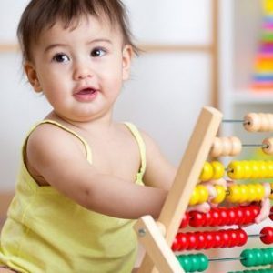 child girl playing with counter in nursery