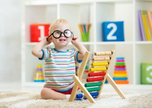 Toddler boy with eyeglasses playing with abacus