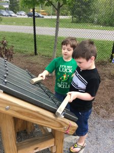 Boys playing on giant zylophone