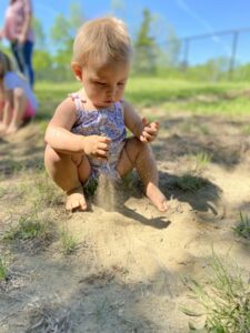 Baby girl playing in sand